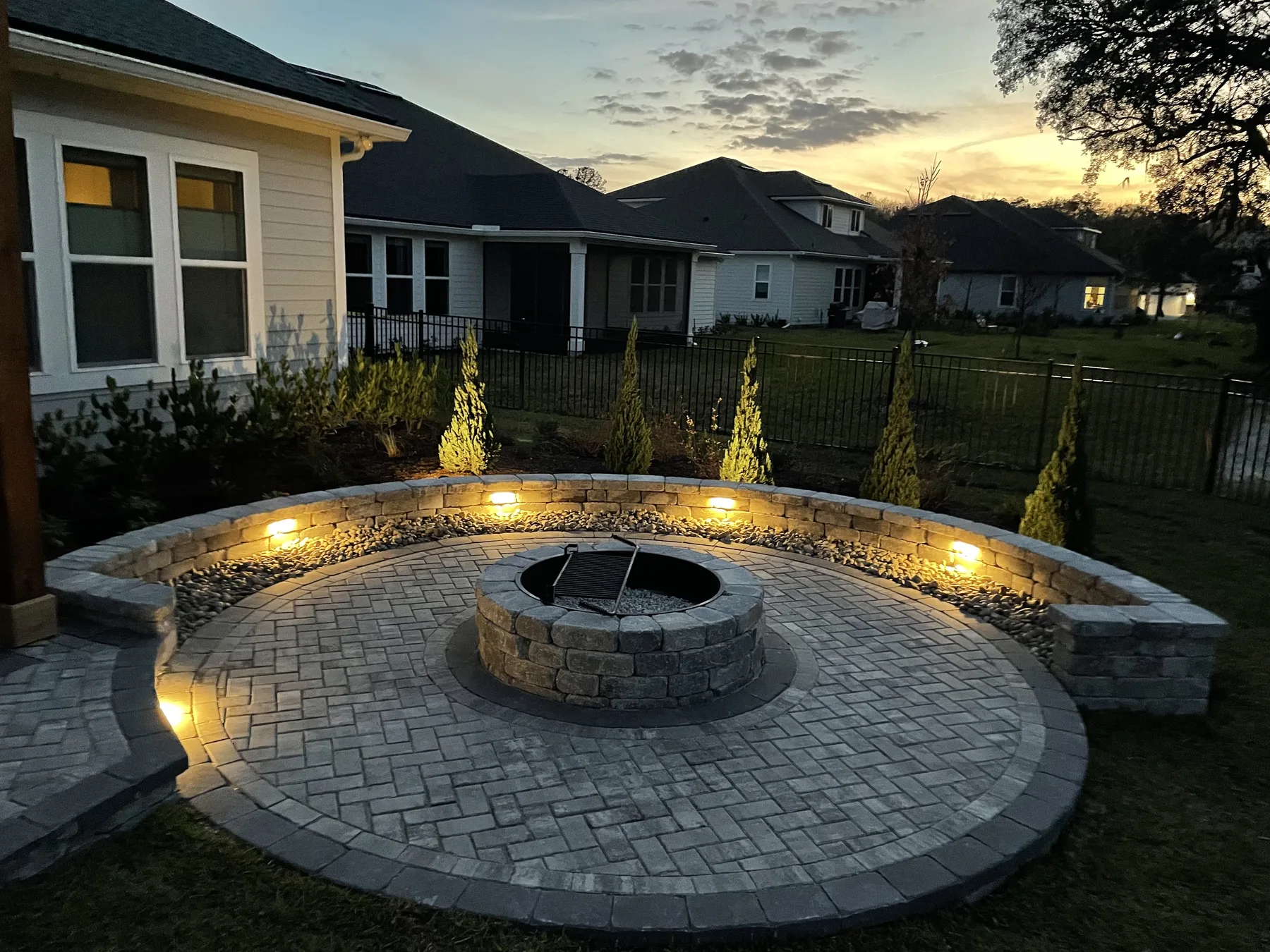 Illuminated paver fire pit patio at dusk in St. Johns, Florida